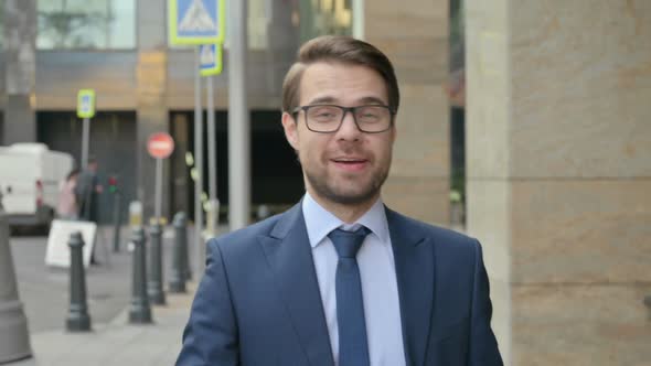 Portrait of Businessman Talking on Online Video Call, Walking in Street