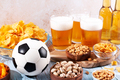 Beer in glasses and snack on wooden table with football ball, football game night food - PhotoDune Item for Sale