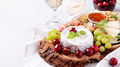Healthy mediterranean cheese and fruits board with white wine on light background - PhotoDune Item for Sale