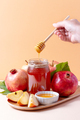 Apples, jar of honey and pomegranates on tray for Jewish holiday Rosh Hashanah - PhotoDune Item for Sale