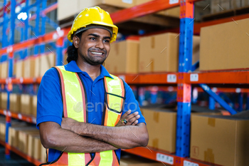 ms crossed smiling to camera standing in the warehouse distribution. Happy employee attitude at the industrial factory