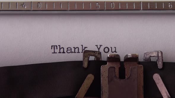 Typing phrase Thank You on retro typewriter. Close up.