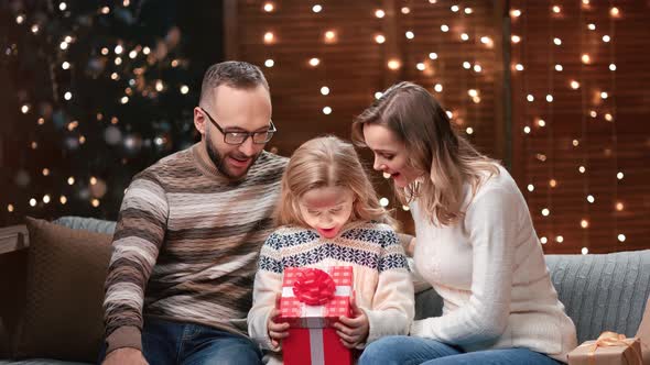 Amazed Family Opening Christmas Gift Box Together