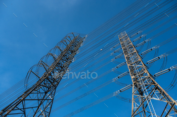 ite tower with connecting wires transferring electricity and network standing tall under blue clear sky