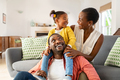 Little black girl playing with parents at home - PhotoDune Item for Sale