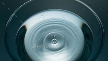 blob transparent liquid diverging circles slow motion. Dripping beverage splashes establishing. Cold filtered water waving moving inside top view