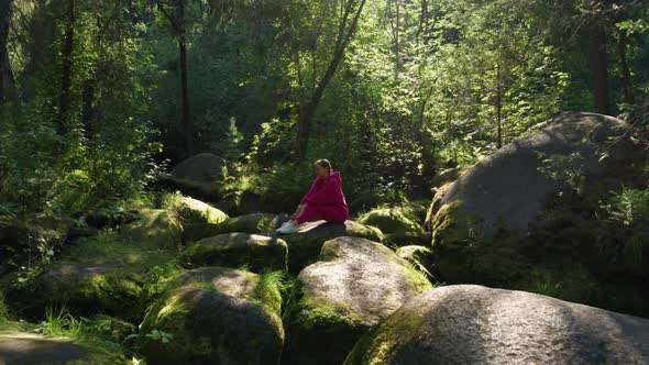 A Girl Practices Yoga in the Forest