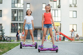 Happy children riding on hoverboards or gyro scooters outdoors in summer. Active life concept. - PhotoDune Item for Sale