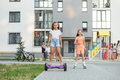 Happy children riding on hoverboards or gyro scooters outdoors in summer. Roller skating. - PhotoDune Item for Sale