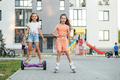 Happy children riding on hoverboards or gyro scooters outdoors in summer. Roller skating. - PhotoDune Item for Sale