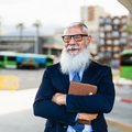 Happy senior business man holding laptop while waiting in bus station - PhotoDune Item for Sale