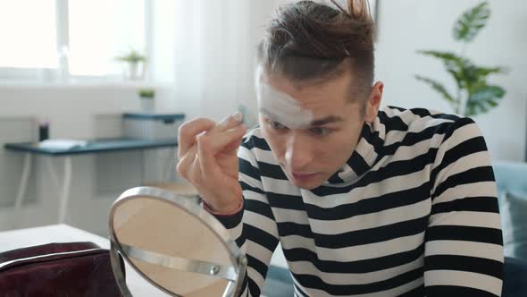 Mime Atrist Putting on Face Paint Looking at Mirror Using Make-up at Home