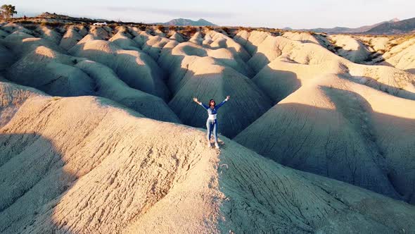 Landscape of dunes desert drone point of view of woman stanging in Mahoya, Spain.