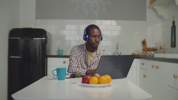 Black Man in Headphones Watching Learning Webinar