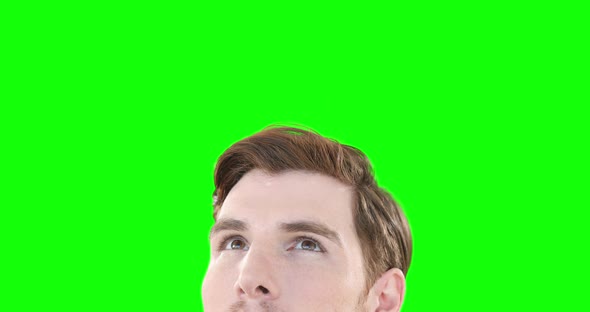 Caucasian man looking up on green background