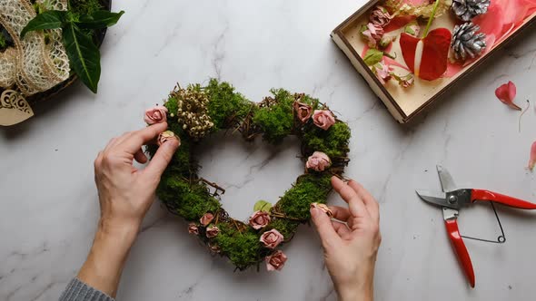 Female Hands Decorates Floral Wreath for Valentines Day