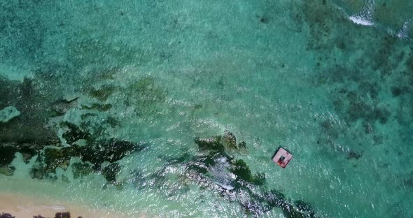 Tropical birds eye tourism shot of a white sand paradise beach and blue water background in colorful