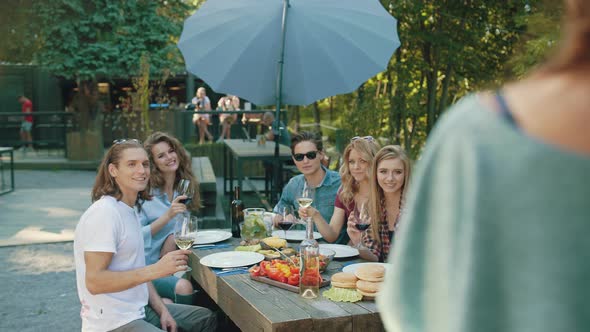 Group Of Friends Drinking Wine And Taking Photos On Phone.