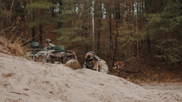 Ace Shooter Sniper Laying on the Ground Aiming to Kill Targets on Battleground Army Patrol Truck in