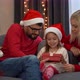 Father Mother and Girl Open Gift Box with Light Next to Christmas Tree at Home - VideoHive Item for Sale