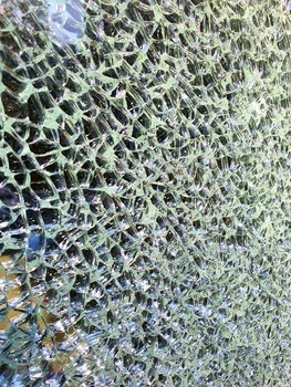 Background: surface of broken triplex glass shards on a black background