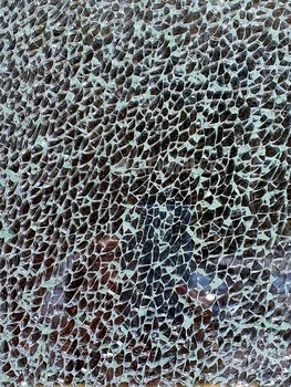 Background: surface of broken triplex glass shards on a black background