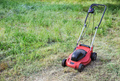 Lawnmower on green grass in the garden - PhotoDune Item for Sale