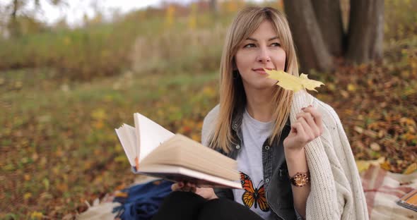 Dreamy Blonde Reading Book in Autumn Park