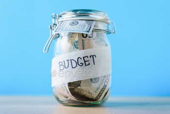with dollar bills and inscription budget on blue background