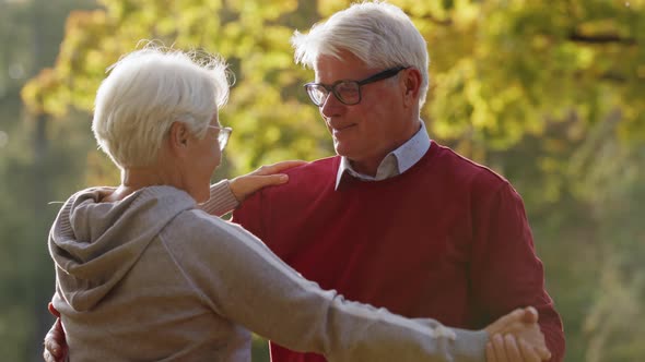 Two Satisfied Pensioners Dancing in the Park Having Fun