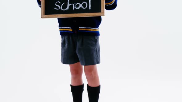 Schoolboy holding chalkboard with back to school text