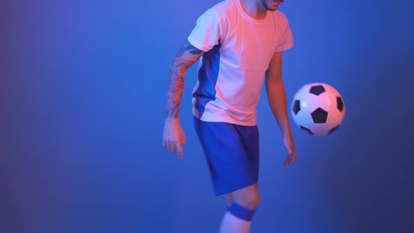 Football Player in White and Blue Juggling in Studio 