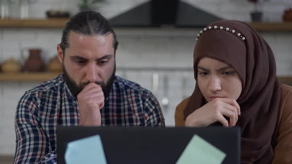 Thoughtful Confused Middle Eastern Husband and Wife Talking Planning Startup Strategy in Home Office
