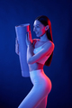 Ready for exercises. Young woman in sportive clothes is in the studio with neon lights - PhotoDune Item for Sale