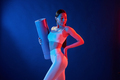 Young woman in sportive clothes is in the studio with neon lights. Holding mat - PhotoDune Item for Sale