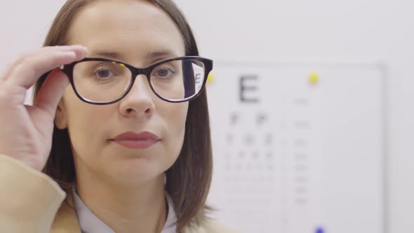 Cheerful Woman in Glasses Smiling at Camera in Ophthalmology Clinic