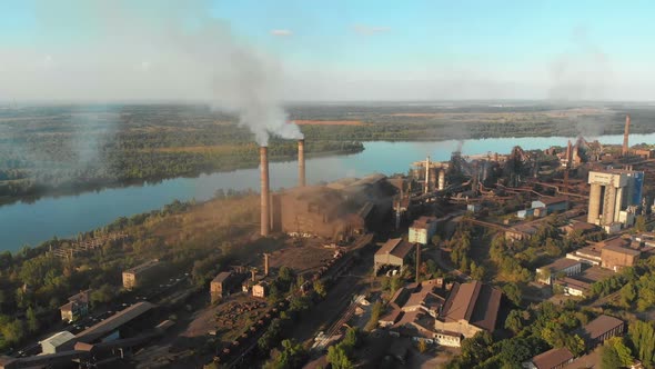 Aerial View of the Industrial Plant with Smoking Pipes Near the City