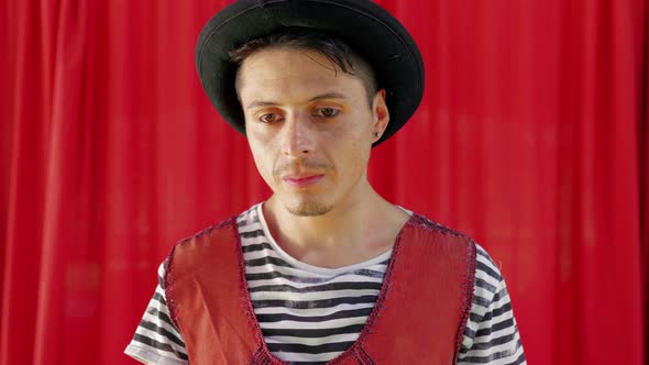 Shy circus artist with hat smiling happily