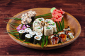 Sushi and rolls on wooden plate with spices and green leaves - PhotoDune Item for Sale