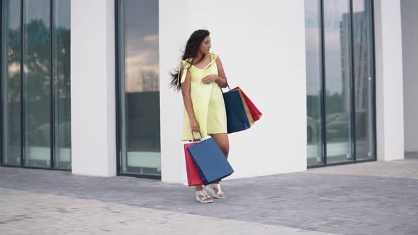 Beautiful Girl Model After Shopping with Colored Bags in Hands