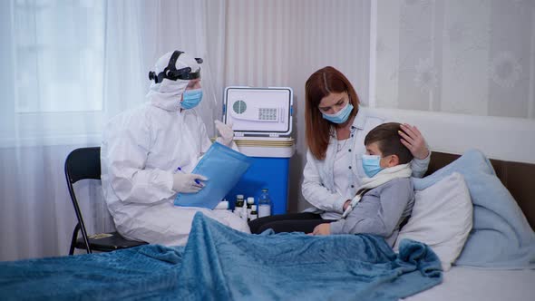 Female Doctor in Protective Suit Wearing Medical Mask and Measuring Temperature with Noncontact