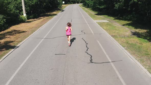 Sportive Attractive Woman Is Running Through City Park