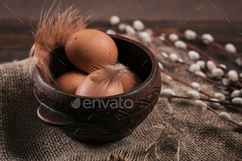 illow branches and feathers on dark wooden background
