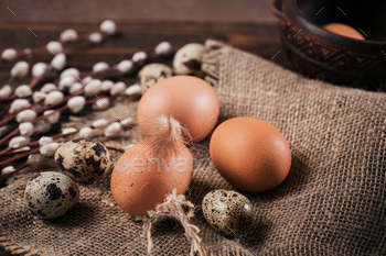illow branches and feathers on dark wooden background
