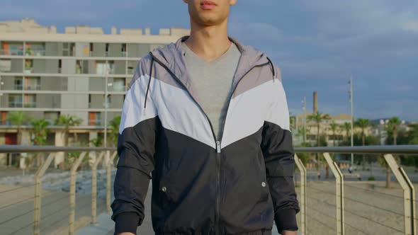 Young attractive athlete walking towards the camera on Bridge in the morning.