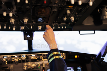 Female copilot pushing buttons and switch on dashboard panel