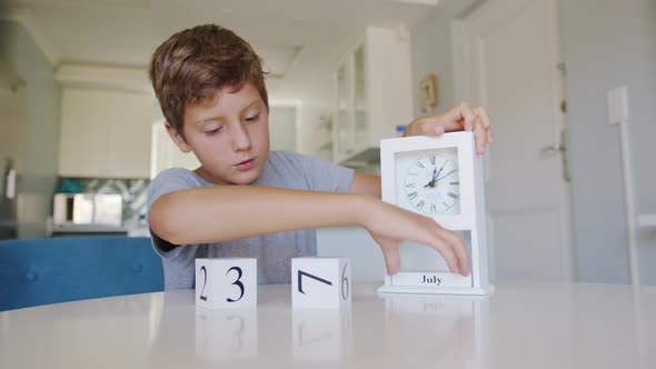 Boy Changing the Date on the Wooden Calendar on July 4 USA Independence Day