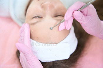 with an uno spoon in a cosmetology clinic. Cropped photo