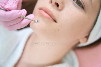 e chin of young client in beauty parlor. Face close-up