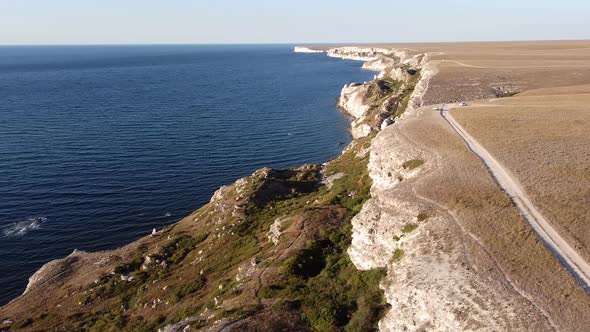 Panorama of the Steep Sea Coast Cliff in the Blue Sea on a Sunny Summer Day